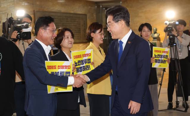 이재명 대통령이 더불어민주당 대표로 재임하던 2023년 6월 19일 서울 여의도 국회 로텐더홀에서 노란봉투법 처리 촉구 피케팅을 하고 있는 정의당 의원들과 인사하고 있다. 연합뉴스