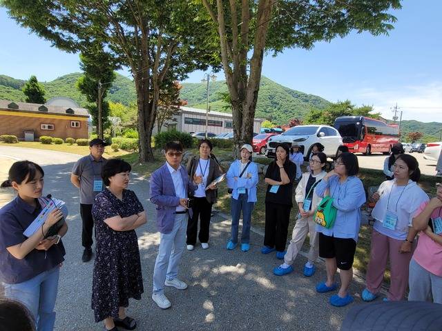 부귀면 작은도서관(사진 맨 왼쪽 건물) 근처 부귀초 운동장에서 안주희 진안교육지원청 주무관(사진 앞줄 왼쪽 첫번째), 부귀초 000 교감, 정성우 교장(3번째, 선글라스 착용)과 이은정 진안교육지원청 장학사(4번째) 등이 학교를 안내하고 있다. / 사진=국승호 기자