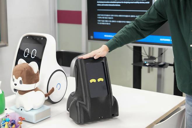 머리를 쓰다듬자 로봇이 눈 웃음을 보이고 있다. [사진=울산과학기술원]