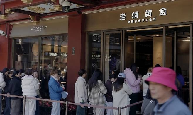 블룸버그통신에 따르면 금 장신구 브랜드 라오푸골드(Laopu Gold)가 중국 젊은 층 사이에서 인기 있는 기업으로 떠오르면서 상장 1년 만에 주가가 1000홍콩달러를 돌파했다. 라오푸골드 제품을 구매하기 위해 매장에 줄을 선 소비자들. [로이터 유튜브 화면 캡처]