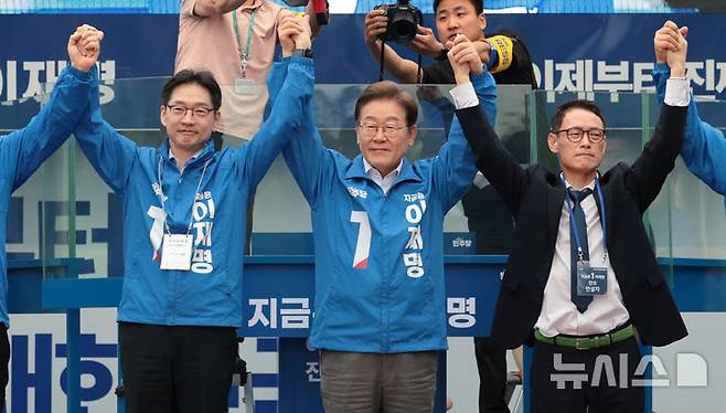 [양산=뉴시스] 조성우 기자 = 이재명 더불어민주당 대선후보가 22일 경남 양산시 양산워터파크공원에서 열린 집중유세에서 김경수(왼쪽) 총괄선대위원장과 찬조연설자의 손을 잡고 시민들을 향해 인사하고 있다. (공동취재) 2025.05.22. photo@newsis.com