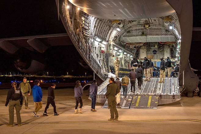 1월23일 미국 애리조나주 투손 국제공항에서 미 공군과 세관국경보호국 요원들이 서류 미비 이민자들을 추방하기 위해 군 수송기에 태우고 있다.ⓒUPI