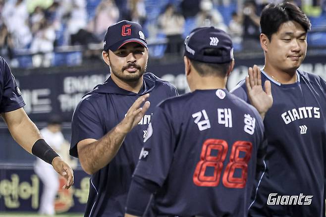 김태형 롯데 감독(가운데)이 8일 잠실구장에서 두산전을 마친 뒤 승리투수 알렉 감보아(왼쪽에서 첫 번째)와 하이파이브를 하고 있다. 롯데자이언츠 제공