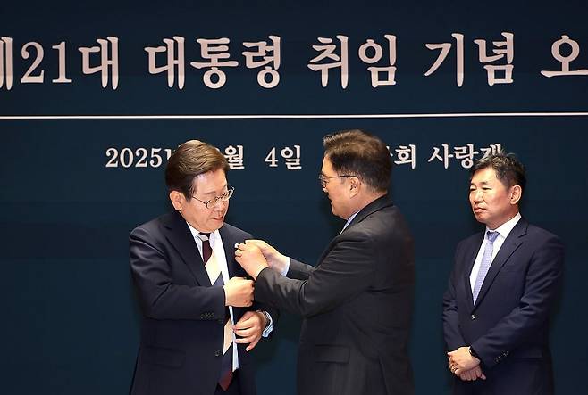 이재명 대통령에게 진관사 태극기 배지 달아주는 우원식 의장 (서울=연합뉴스) 우원식 국회의장이 4일 국회 사랑재에서 열린 제21대 이재명 대통령 취임기념 오찬에서 이 대통령에게 '진관사 태극기' 배지를 달아주고 있다. 2025.6.4 
    [우원식 국회의장 페이스북. 재판매 및 DB 금지] photo@yna.co.kr