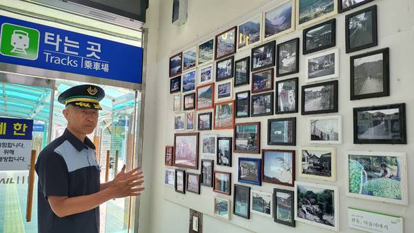 원동역 사내 벽에 걸려 있는 원동역 사진을 여행자들에게 설명하고 있는 김용옥 원동역장.