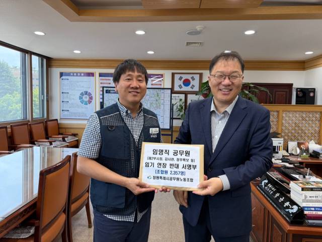 손민배(왼쪽) 창원시공무원노조 위원장이 장금용 시장권한대행을 만나 ‘임명직 공무원 임기 연장 반대 서명부’를 전달하고 있다. 창원시공무원노조 제공