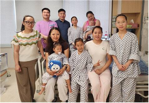 부천세종병원에서 의료나눔을 통해 치료받은 몽골 국적 심장병 환아들이 회복 후 병동에서 보호자와 함께 기념 촬영하고 있다. 부천세종병원 제공