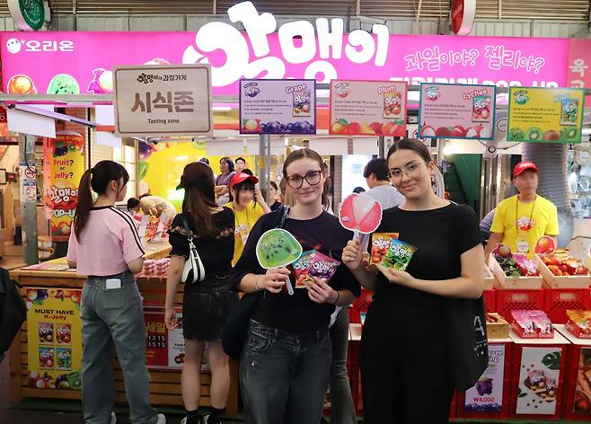 지난 2월 서울 종로구 광장시장에서 열린 '알맹이네 과일가게 시즌2' 팝업스토어에서 외국인 관광객들이 '알맹이' 젤리를 들고 사진을 찍고 있다.(오리온 제공)
