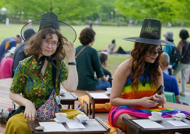 지난달 22일 서울 동작구 보라매공원에서 열린 ‘서울국제정원박람회’를 찾은 외국인 관광객들이 갓을 쓰고 정원에 대한 설명을 듣고 있다. 서울시 제공