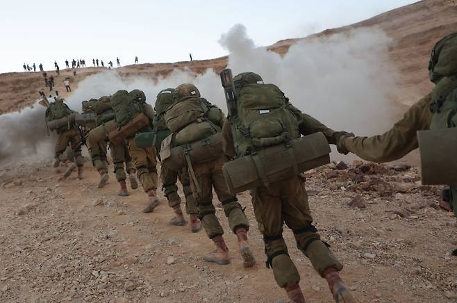 지난달 29일(현지 시간) 이스라엘 사해 인근 마사다에서 이스라엘군(IDF) 신병들이 40㎞, 10시간 행군을 하고 있다. 천혜의 요새 마사다는 서기 73년 로마군의 무력에 싸우던 이스라엘군이 패색이 짙어지자, 노예가 되길 거부하며 전원 자결한 곳으로 유대인의 민족정신을 상징하는 성지이다. 마사다=신화 뉴시스