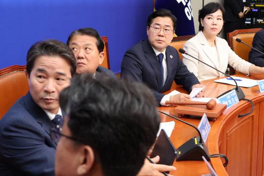 더불어민주당 박찬대 당대표 직무대행 겸 원내대표와 최고위원들이 9일 국회 본청에서 열린 최고위원회의에서 이재명 대통령 취임 후 상승세를 기록 중인 코스피 등이 표시된 경제위기상황판을 확인하고 있다.<연합뉴스 사진>