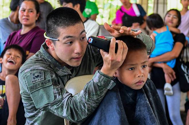 2025 카만닥 훈련에 참가한 해병대 장병이 지난 2일 필리핀 베롱해안 마을 체육관에서 현지 아이들을 대상으로 이발, 레크레이션, 선물 전달 등의 대민지원활동을 실시하고 있다. 해병대 제공