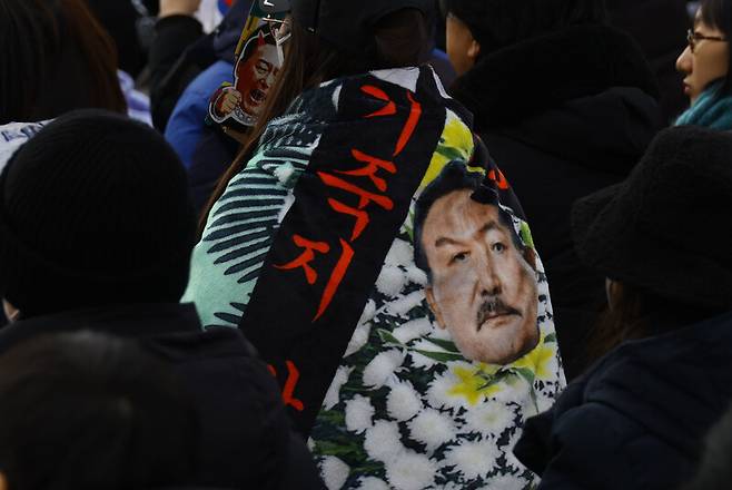 지난 1월25일 오후 ‘윤석열 즉각퇴진·사회대개혁 비상행동’ 주최로 열린 퇴진 촉구 집회에서 참가자들이 내란 피의자 윤석열 전 대통령을 히틀러처럼 풍자한 천을 두르고 있다. 윤운식 선임기자 yws@hani.co.kr