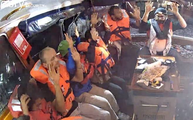 그레타 툰베리 등 12명의 국제 활동가들이 탄 자유선단연합의 매들린호가 9일 새벽 3시께 이스라엘군에 나포됐다. 활동가들이 두 손을 들고 있다. 자유선단연합 제공