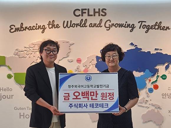 최성철(왼쪽) 테코테크 대표가 9일 청주외국어고등학교 교장실에서 발전기금 500만원을 기탁한 뒤 정은영(오른쪽) 청주외고 교장과 사진을 찍고 있다. [사진=충북교육청]