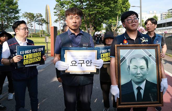 엄길용 공공운수노조 위원장, 유족, 태안화력발전소 사고 대책위 관계자들이 지난 6일 서울 용산 대통령실 청사 인근 전쟁기념관 앞에서 사고 희생자 고(故) 김충현 씨와 관련해 강훈식 대통령비서실장에게 요구 서한 전달하기 위해 이동하고 있다. 연합뉴스&nbsp;