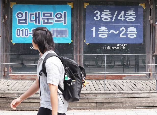 8일 관계부처에 따르면 정부는 기획재정부를 중심으로 2차 추경 편성 작업에 돌입했다. 20조원+α(알파)로 예상되는 2차 추경은 전 국민 25만원 지역화폐(소비쿠폰) 지급을 비롯한 소상공인 지원에 집중될 것으로 보인다. 지난달 28일 한 시민이 서울 서대문구에서 임대 안내문이 붙은 빈 상가 앞을 지나가고 있다. 연합뉴스