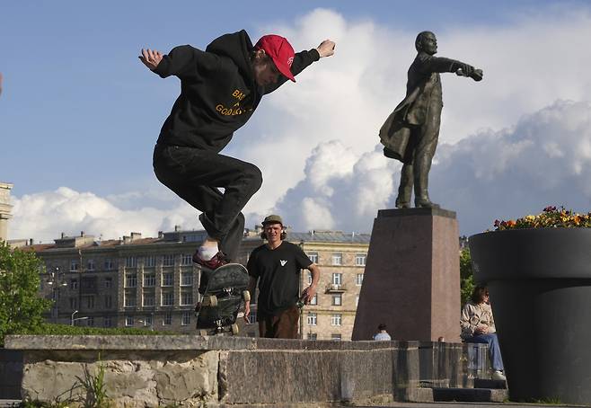 러시아 제2의 수도 상트페테르부르크에서 지난 3일(현지시간) 스케이트 보드를 타는 청년이 레닌 동상 옆을 달리고 있다. [AP]