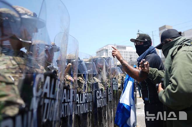 [로스앤젤레스=AP/뉴시스] 8일(현지 시간) 미 캘리포니아주 로스앤젤레스 도심에서 이민세관단속국(ICE)의 불법 이민자 단속 및 체포에 항의하는 시위대가 경찰과 충돌하고 있다. 도널드 트럼프 대통령은 불법 이민자 단속에 항의하는 시위 참가자들은 마스크를 착용해서는 안 된다고 밝혔다. 2025.06.09.