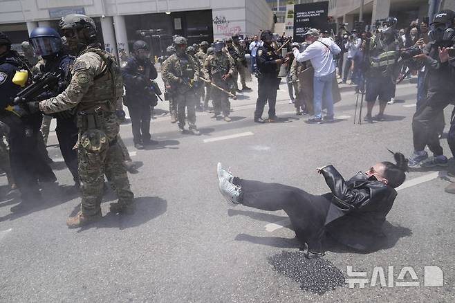 [로스앤젤레스=AP/뉴시스] 8일(현지 시간) 미 캘리포니아주 로스앤젤레스 도심에서 이민세관단속국(ICE)의 불법 이민자 단속 및 체포에 항의하는 시위대가 경찰과 충돌하고 있다. 도널드 트럼프 대통령은 불법 이민자 단속에 항의하는 시위 참가자들은 마스크를 착용해서는 안 된다고 밝혔다. 2025.06.09.