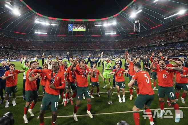 [뮌헨=AP/뉴시스] 포르투갈 선수들이 8일(현지 시간) 독일 뮌헨의 알리안츠 아레나에서 열린 2024-25 유럽축구연맹(UEFA) 네이션스리그(UNL) 스페인과의 결승전에서 승리해 우승한 후 트로피를 들고 환호하고 있다. 포르투갈은 연장까지 2-2 무승부를 기록해 승부차기 끝에 5-3으로 승리해 6년 만에 정상에 올랐다. 크리스티아누 호날두는 후반 16분 동점 골을 넣어 A매치 138호 골을 기록했다. 2025.06.09.