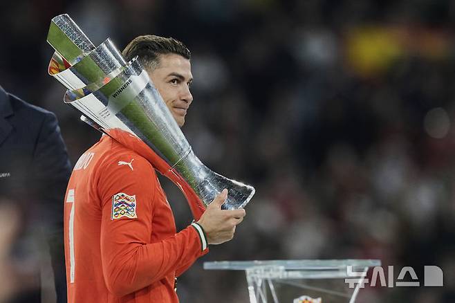 [뮌헨=AP/뉴시스] 포르투갈의 크리스티아누 호날두가 8일(현지 시간) 독일 뮌헨의 알리안츠 아레나에서 열린 2024-25 유럽축구연맹(UEFA) 네이션스리그(UNL) 스페인과의 결승전에서 승리해 우승한 후 트로피를 어깨에 메고 미소 짓고 있다. 포르투갈은 연장까지 2-2 무승부를 기록해 승부차기 끝에 5-3으로 승리해 6년 만에 정상에 올랐다. 호날두는 후반 16분 동점 골을 넣어 A매치 138호 골을 기록했다. 2025.06.09.