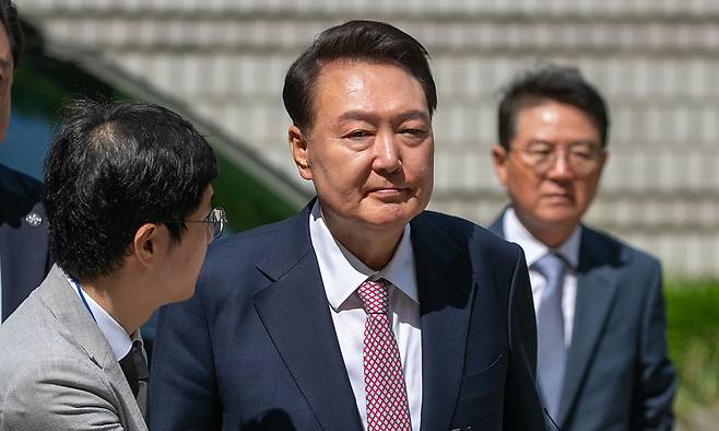 취재진 질문에 묵묵부답 윤석열 전 대통령이 9일 서울 서초구 서울중앙지방법원에서 열린 내란 우두머리 혐의 사건 6차 공판에 출석하기 위해 취재진 사이를 지나고 있다. 윤 전 대통령은 대선 후 처음으로 포토라인에 섰지만, 특검 등에 대한 질문에는 침묵했다. 사진공동취재단