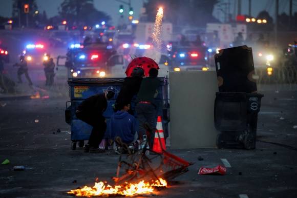대치 - 7일(현지시간) 미국 캘리포니아주 로스앤젤레스(LA) 남쪽 패러마운트 지역에서 이민세관단속국(ICE)의 대규모 불법 체류자 체포에 반대하는 시위대가 도로에 바리케이드를 세우고 경찰과 대치하고 있다. 전날 ICE 요원들은 이 지역 의류 공장을 급습해 히스패닉계 이민자를 체포했고 이 과정에서 공포탄도 사용했다. 이에 LA에서 도널드 트럼프 대통령의 불법 이민자 추방 정책에 항의하는 대규모 시위가 시작됐다. 패러마운트 로이터 연합뉴스