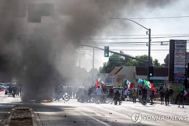 8일 오전 LA 남쪽 콤프턴 지역에서 시위대와 당국이 충돌하는 모습  [AFP=연합뉴스. 재판매 및 DB 금지]