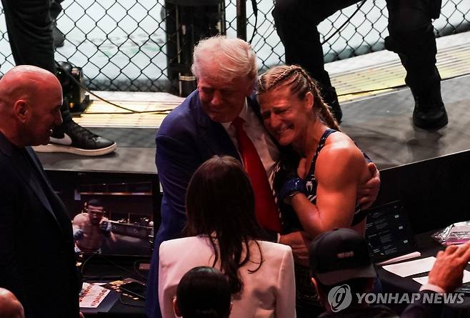 트럼프 미국 대통령에게 안겨 있는 UFC 챔피언 해리슨 [로이터=연합뉴스]