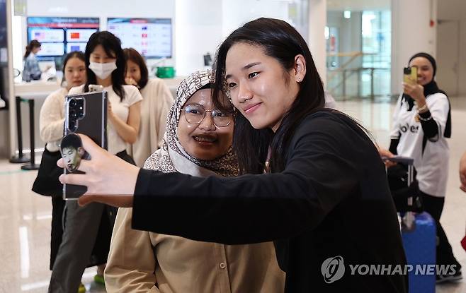 팬서비스 잊지 않는 안세영 (영종도=연합뉴스) 김인철 기자 = 세계배드민턴연맹(BWF) 월드투어 슈퍼 1000 인도네시아오픈 여자 단식 결승에서 우승을 차지한 안세영이 9일 인천국제공항 제2여객터미널로 귀국한 뒤 한 외국인 팬과 기념촬영을 하고 있다. 2025.6.9 yatoya@yna.co.kr