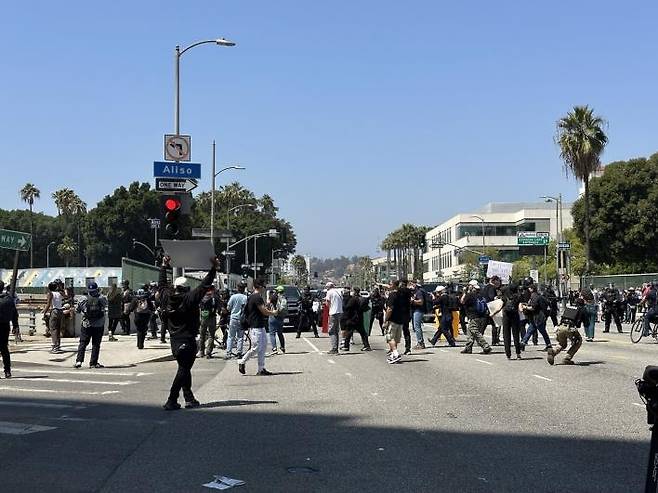LA에서 경찰과 대치한 시위대 (로스앤젤레스=연합뉴스) 임미나 특파원 = 8일(현지시간) 미국 로스앤젤레스(LA) 도심의 연방 구금시설인 '메트로폴리탄 디텐션 센터'(Metropolitan Detention Center, 이하 MDC) 앞 대로에서 경찰과 시위대가 대치하고 있다. 시위대는 미 이민세관단속국(ICE)의 대대적인 불법이민자 단속에 반발하는 시위를 사흘째 벌이고 있다. mina@yna.co.kr