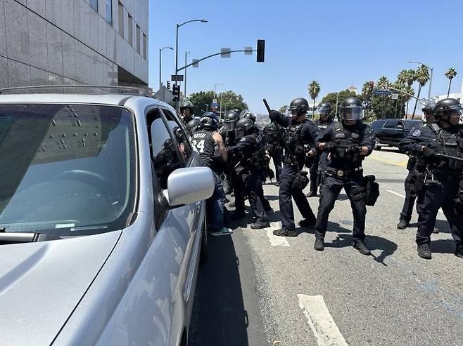 LA 경찰에 구타당하고 체포되는 시위대의 한 남성  (로스앤젤레스=연합뉴스) 임미나 특파원 = 8일(현지시간) 미국 로스앤젤레스(LA) 도심의 연방 구금시설인 '메트로폴리탄 디텐션 센터'(Metropolitan Detention Center, 이하 MDC) 앞에서 경찰이 시위대의 한 남성을 구타한 뒤 체포하고 있다. 시위대는 미 이민세관단속국(ICE)의 대대적인 불법이민자 단속에 반발하는 시위를 사흘째 벌이고 있다. mina@yna.co.kr