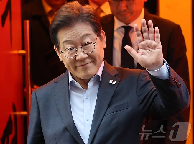 이재명 더불어민주당 대통령 후보가 5월 1일 서울 종로구의 한 포차 식당에서 '당신의 하루를 만드는, 보이지 않는 영웅들'이란 주제로 열린 배달 라이더, 택배 기사 등 비(非)전형 노동자들과 간담회를 마친 뒤 나서며 손인사를 하고 있다. (공동취재) 2025.5.1/뉴스1 ⓒ News1 이재명 기자