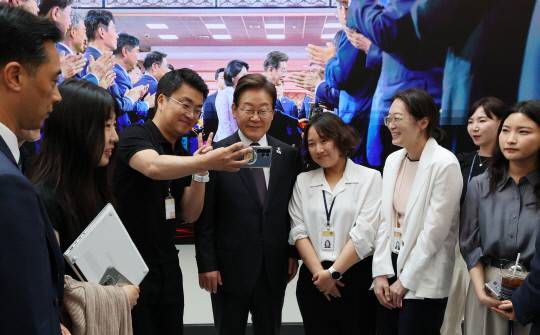 이재명 대통령이 10일 서울 용산 대통령실 청사 직원 식당에서 점심 식사를 한 뒤 마주친 출입 기자들과 셀카를 촬영하고 있다.연합뉴스