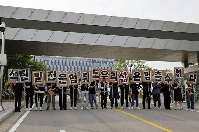 석탄화력발전소 비정규직 노동자들이 2025년 5월31일 오후 ‘공공재생에너지 확대! 발전노동자 총고용 보장! 정의로운 전환을 위한 5·21 노동자·시민 대행진’을 마친 뒤 충남 태안군 태안읍 평천리 한국서부발전 본사 앞에서 고용보장을 요구하는 손팻말을 들고 있다. 김명진 기자