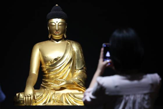 9일 서울 용산구 국립중앙박물관에서 열린 '새 나라 새 미술:조선 전기 미술 대전' 특별전 언론공개회에서 관계자가 조계사 목조여래좌상을 살펴보고 있다. 국립중앙박물관 용산 개관 20주년을 맞이해 열린 이번 특별전은 조선이라는 새로운 나라의 시작과 함께 꽃핀 15~16세기 미술의 정수를 한 자리에 모은 대규모 기획이다. 전시는 오는 8월 31일까지 열린다. 뉴스1