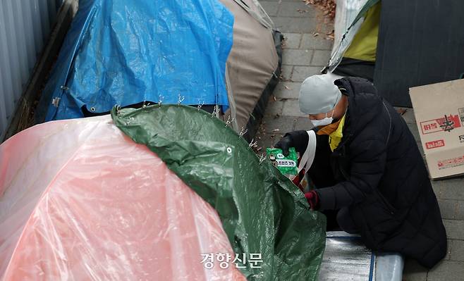 지난 2월 5일 서울 중구 서울역 인근 노숙인 텐트촌에서 서울특별시립다시서기 서울역희망지원센터 이형운 팀장이 노숙인들에게 방한용품과 간식을 나눠주고 있다./권도현 기자