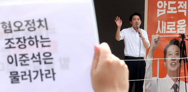 A protester holds a sign reading “Step down, Lee Jun-seok, who incites politics of hate,” directed at Rep. Lee Jun-seok, the New Reform Party’s candidate for the June 3 presidential election, during a campaign event in Seoul on May 30. (Newsis)