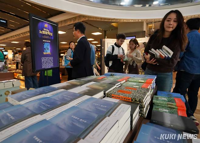 서울 종로구 교보문고 광화문점에 마련된 한강 작가 코너에서 시민들이 작가의 작품을 살펴보고 있다. 유희태 기자