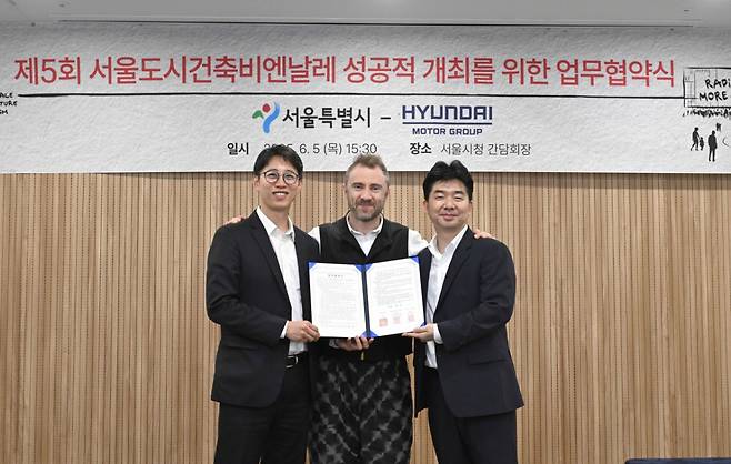 현대자동차그룹이 서울 중구 서울시청에서 서울시가 주최하는 ‘제5회 서울도시건축비엔날레’를 후원하는 업무 협약을 체결했다고 10일 밝혔다. (왼쪽부터) 서울시 안중욱 미래공간담당관, 토마스 헤더윅 총감독, 현대차그룹 홍래욱 글로벌디자인매니지먼트팀 상무가 기념 촬영을 하고 있다. /사진제공=현대차그룹