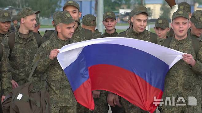 [모스크바=AP/뉴시스] 9일(현지 시간) 러시아 국방부가 공개한 영상 사진에 우크라이나와 포로 교환으로 석방된 러시아 군인들이 러시아 모스크바 외곽 공항에 도착해 국기를 들고 수송기에서 내리고 있다. 러시아와 우크라이나가 25세 미만과 중상자 포로를 교환했다. 2025.06.10.