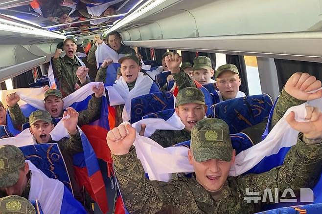 [모스크바=AP/뉴시스] 9일(현지 시간) 러시아 국방부가 공개한 영상 사진에 우크라이나와 포로 교환으로 석방된 러시아 군인들이 러시아 모스크바 외곽 공항에 도착 후 버스에 탑승해 국기를 들고 환호하고 있다. 러시아와 우크라이나가 25세 미만과 중상자 포로를 교환했다. 2025.06.10.