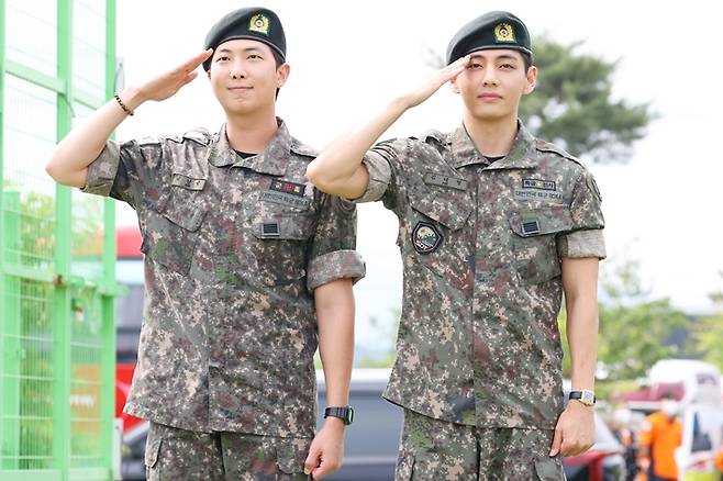 육군 현역 복무를 마치고 만기 전역한 그룹 방탄소년단(BTS) RM(왼쪽)과 뷔가(오른쪽) 10일 강원 춘천시 신북읍체육공원에서 취재진을 향해 거수경례하는 모습. 연합뉴스