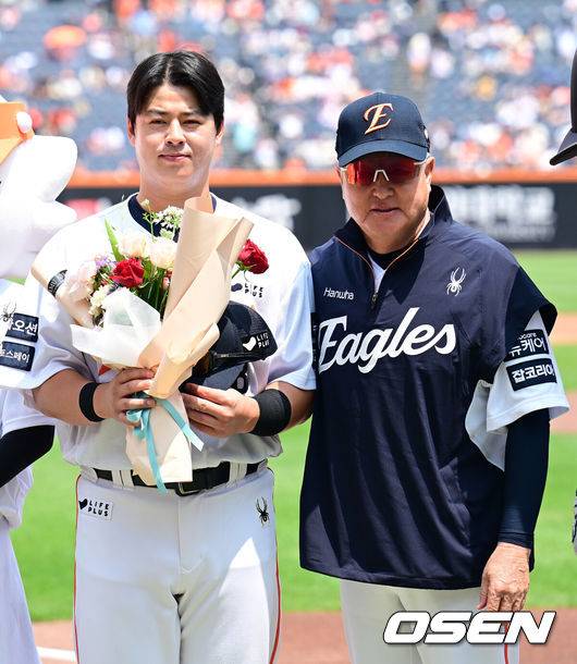 [OSEN=대전, 김성락 기자] 한화 노시환이 김경문 감독에게 역대 108번째 통산 100홈런을 기념 꽃다발을 전달 받은 뒤 기념촬영을 하고 있다. 2025.06.03 / ksl0919@osen.co.kr