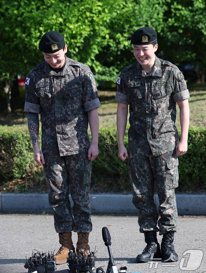 방탄소년단(BTS)의 정국과 지민(오른쪽)이 11일 오전 경기도 연천군 연천공설운동장에서 전역 인사를 하기 전 수줍은 미소를 짓고 있다.  ⓒ News1 권현진 기자