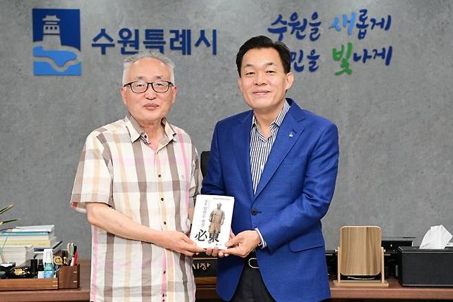 이재준 수원시장(오른쪽)과 박환 고려학술문화재단 이사장이 평전을 들고 기념 촬영을 하고 있다. ⓒ수원시 제공