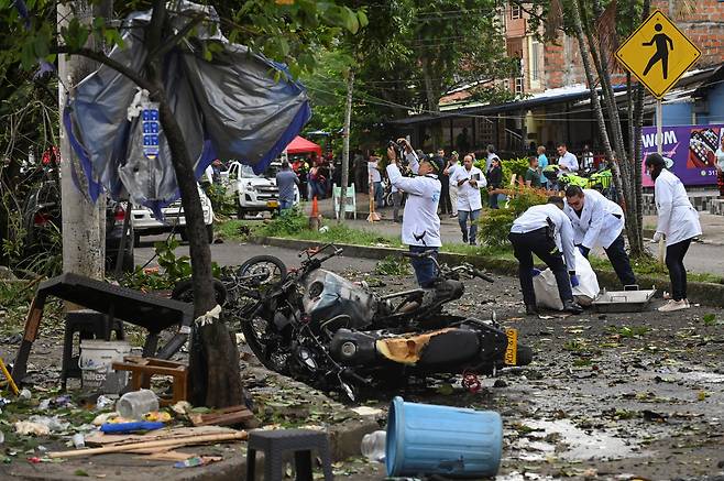 법의학자들이 10일(현지시간) 콜롬비아 칼리주 멜렌데즈 인근 경찰서 앞에서 폭발 사고 현장을 조사하고 있다. 로이터=연합뉴스