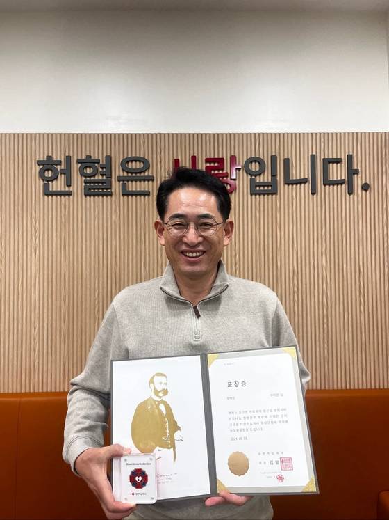 우익원 괴산군청 과장이 지난해 10월 헌혈 100회 달성 기념으로 헌혈 유공장을 들고 웃고 있다. 사진 우원익 과장 페이스북