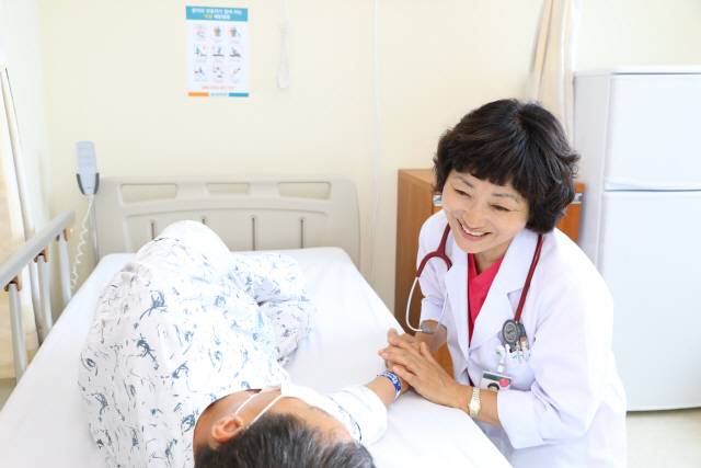 ▲ 강릉아산병원 63병동에서 근무하는 이영이 입원전담 전문의가 환자와 대화하고 있다.